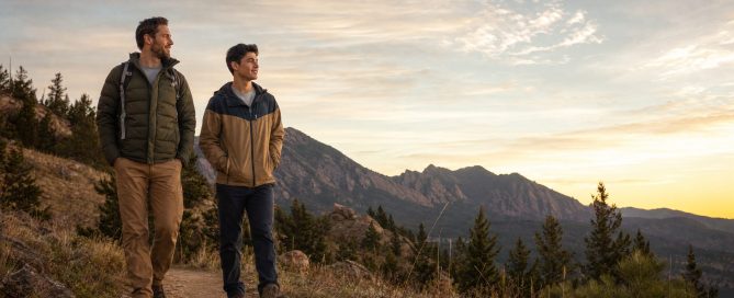 Mentor and young man walking side by side in easy companionship on a Colorado Front Range trail at golden hour